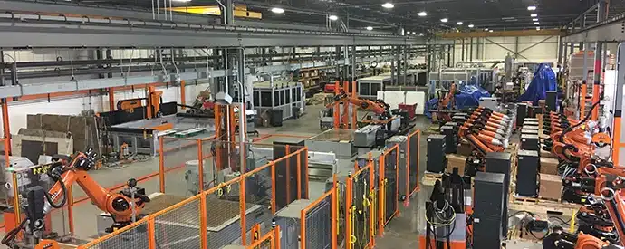 Aerial view of an advanced manufacturing facility featuring multiple robotic arms and automated machinery.
