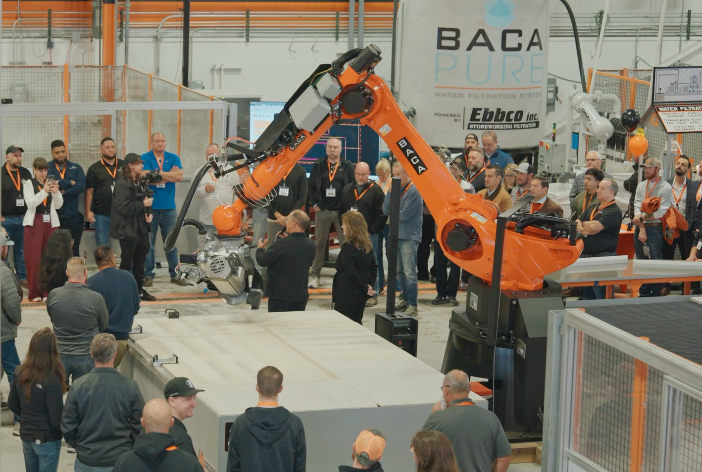 BACA Bash 2026 presentation in front of M Series 240 Robot with a crowd of fabricators