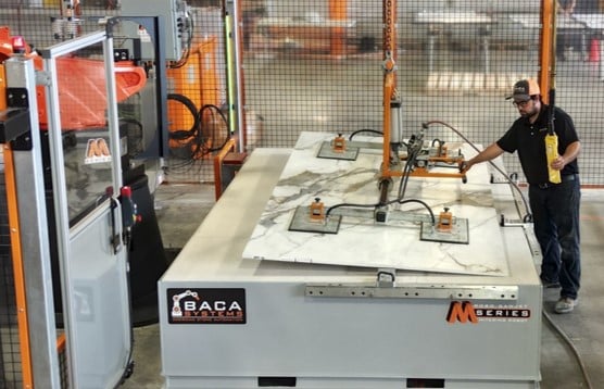 Loading stone slab onto BACA Robo SawJet M Series 240 cutting table into hard stops for positioning